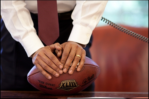 President Barack Obama Leans on a Football