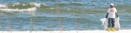 photo of a cleanup worker on holding plastic bags