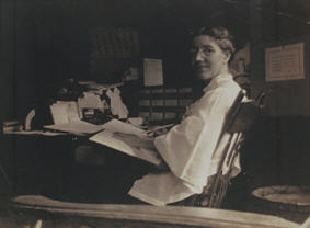 Charlotte Perkins Gilman writing at her desk, ca. 1916-1922.