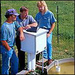 Tres hombres trabajando en un contendor de agua