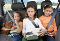 Tres niños en el asiento trasero del auto