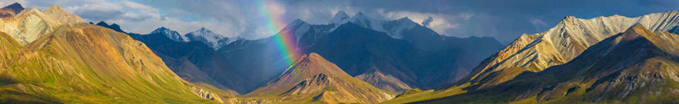 Image of rainbow over river, mountains