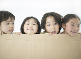 4 preschoolers looking out of a box