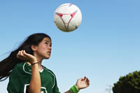 Photo: girl bouncing a soccer ball off her head