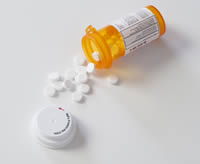 Photo: prescription pill bottle  with pills spilling out