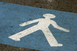 photo of walking sign on pavement near crosswalk