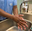 Doctor washing hands in a hospital sink.