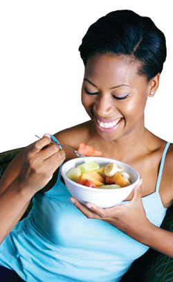 Pregnant woman eating fruit.