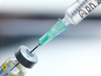 a close up of a sterile syringe inserted into an insulin bottle