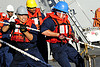 Sailors pull a line during a replensihment at sea.