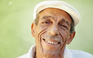Un hombre mayor con gorro blanco sonríe