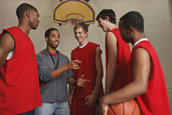 Photo: Male teen basketball players talking to their coach