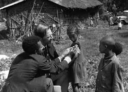 Dr. D. A. Henderson helping a child with smallpox