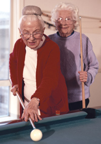 Two older women playing billiards