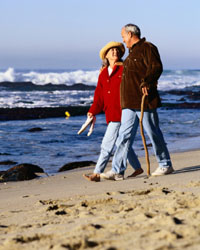 Photo: A man and woman walking on the beach.