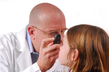 Médico examinando el ojo de una niña