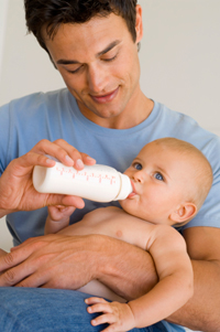 Photo: A father bottle feeding an infant