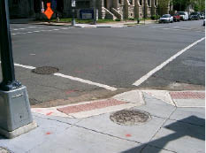 Paired curb ramps with detectable warnings at corner.