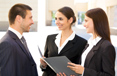 3 young professionals looking over a file folder