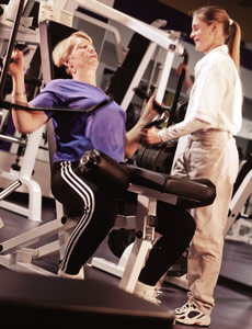 A lady working out at the gym with a personal trainer