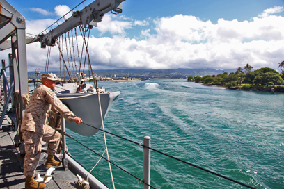 ABOARD USS RUSHMORE - A Marine from the 15th Marine Expeditionary Unit watches as the USS Rushmore leaves U.S. Naval Base Pearl Harbor, Hawaii, a week into the unit