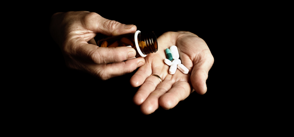 Hand pouring pills out of a bottle