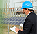 Photo of a man in a hardhat with a clipboard.