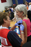 The Secretary of Health and Human Services receives a vaccination from a Virginia MRC volunteer.