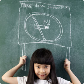 Young girl pretend holding a no smoking sign on black board