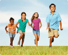 Multiracial children running on grass
