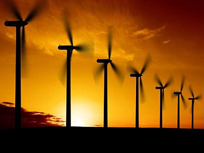 Photo is a silhouette of seven wind turbines.