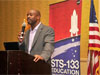 Leland Melvin speaks into a microphone