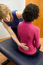 A woman performing spinal manipulation.