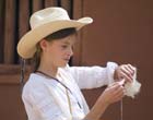 Photo of a young girl spinning wool into yarn along the El Camino Real de Tierra Adentro National Historic Trail