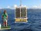 Photo of a researcher on a research vessel watching seawater sampling equipment.