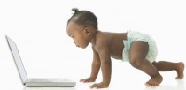 Photo of toddler crawling toward a white laptop.