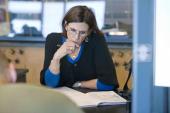 Woman in glasses reading notes