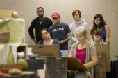 Group of students looking over teacher's shoulder