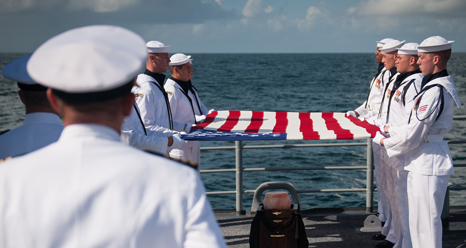 Members of the U.S. Navy ceremonial guard hold an American flag over the cremains of Apollo 11 astronaut Neil Armstrong during a burial at sea service aboard the USS Philippine Sea, Friday, Sept. 14, 2012, in the Atlantic Ocean. Armstrong, the first man to walk on the moon during the 1969 Apollo 11 mission, died Saturday, Aug. 25. He was 82. Photo Credit: NASA/Bill Ingalls