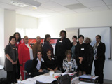 Thirteen women from the Baltimore Champions pose together in front of a Heart Truth display.
