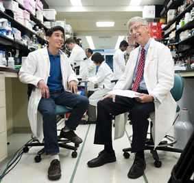 NIH director Dr. Francis Collins (r) talks about work on an HIV vaccine with Dr. Peter Kwong of the VRC at the Saturday event.