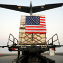 flag-draped cargo being loaded onto airplane