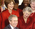 Image of then President George W. Bush, Heart Truth Founding Ambassador Laura Bush, and heart disease survivors in red dresses, signs an American Heart Month Proclamation on February 2, 2004.