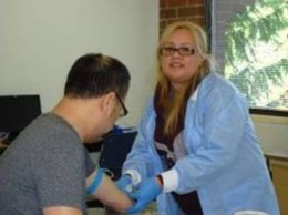 Luz Torres prepares to draw blood from a patient.