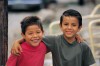 Two Hispanic boys laughing and smiling with each other.