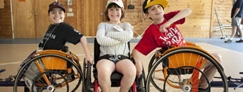 Tres niños con espina bifida en silla de ruedas