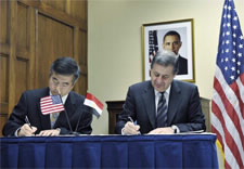 Locke and Rachid seen signing document. Click for larrger image.