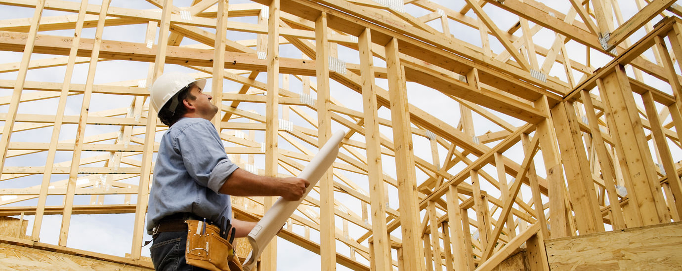 Man inspecting a wooden frame roof