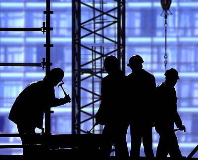 silhouettes of workers in front of scaffolding