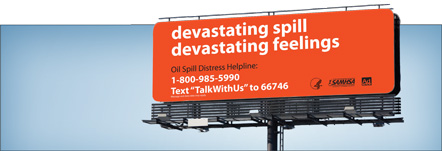 Billboard advertising the Oil Spill Distress Helpline with the language Devastating Spill, Devastating Feelings, Oil Distress Helpline: 1-800-985-5990, Text TalkWithUs to 66746